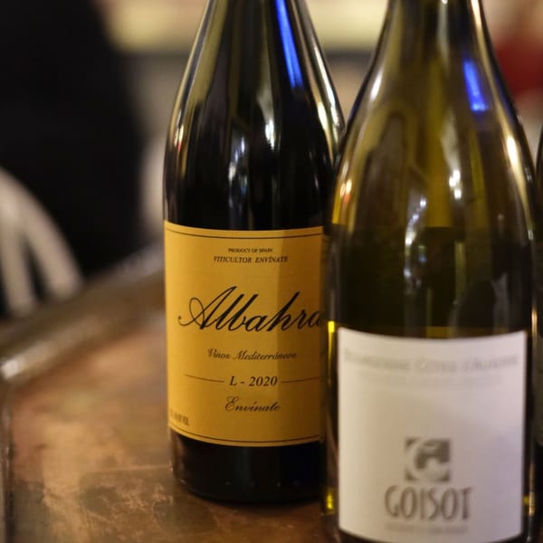 Two wine bottles, one with a yellow "Albahra" label and another with a white "Goisot" label.