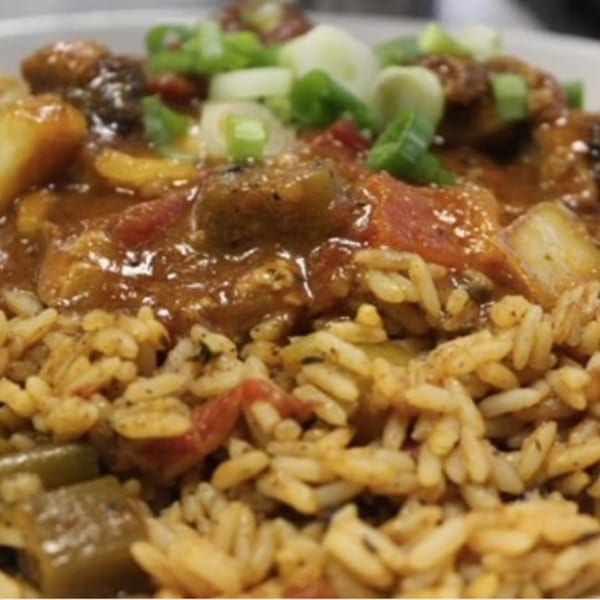 Close-up of BrewRiver Creole Kitchen's jambalaya with rice, meat, vegetables, and green onions.